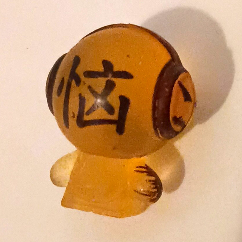 mini figurina personaggio giocattolo con cuffie, marrone/trasparente - 1 in
