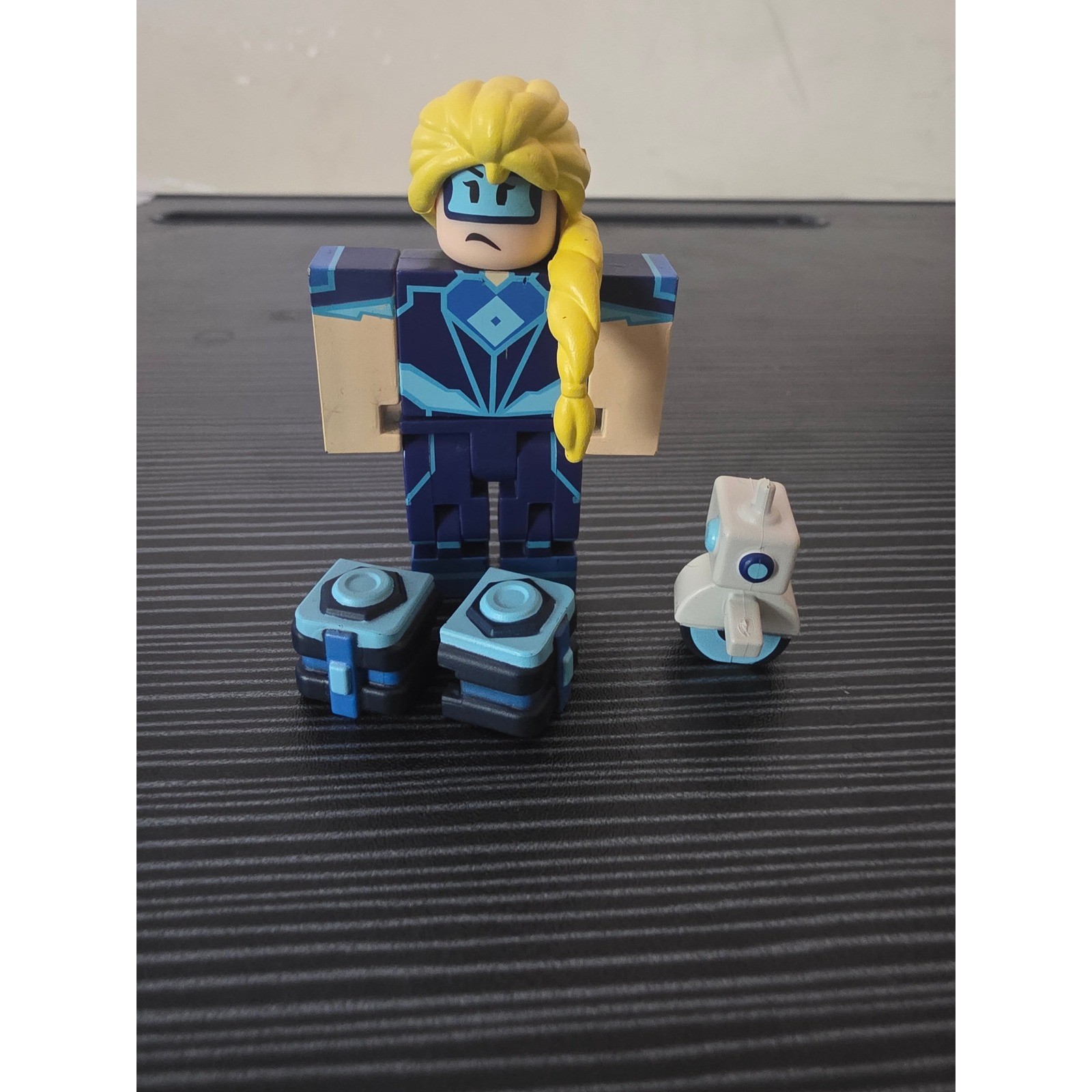 Roblox Jazwares Action Figure Eroe Biondo Tuta Blu con Robot e Casse Set