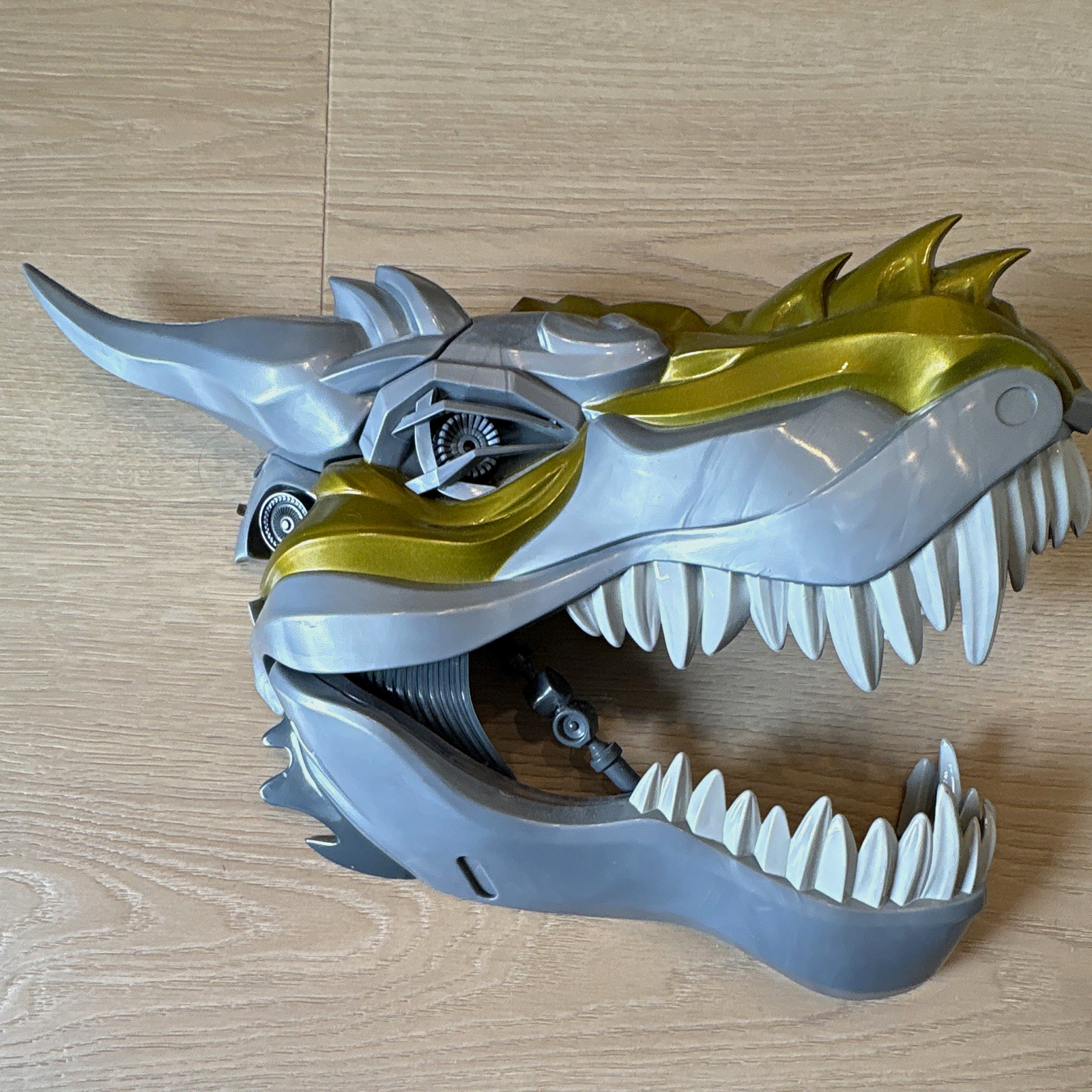 Maschera giocattolo testa di dinosauro Tyrannosaurus Rex con occhio illuminato - grigio/oro/bianco