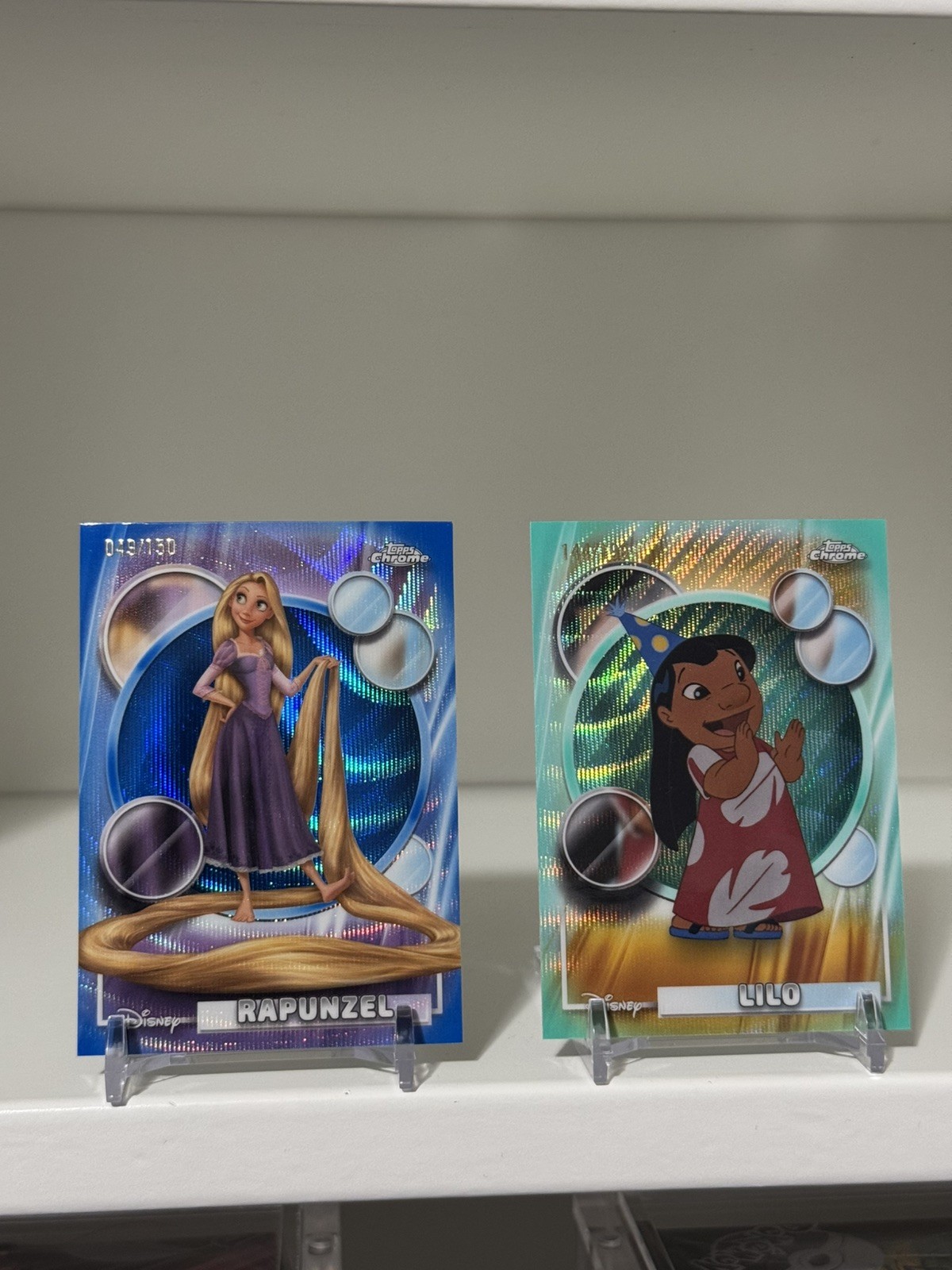 2026 Topps Chrome Disney Raperonzolo blu rifrattore aggrovigliato 112/150+ Lilo /199 Aqua