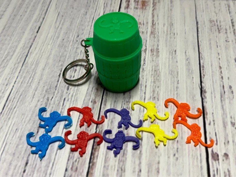 Scimmia In A Barrel Mini Gioco Portachiavi Barile Verde Miniatura Figura Giocattolo